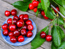 Cherries on a Blue Plate on a Table in the Garden